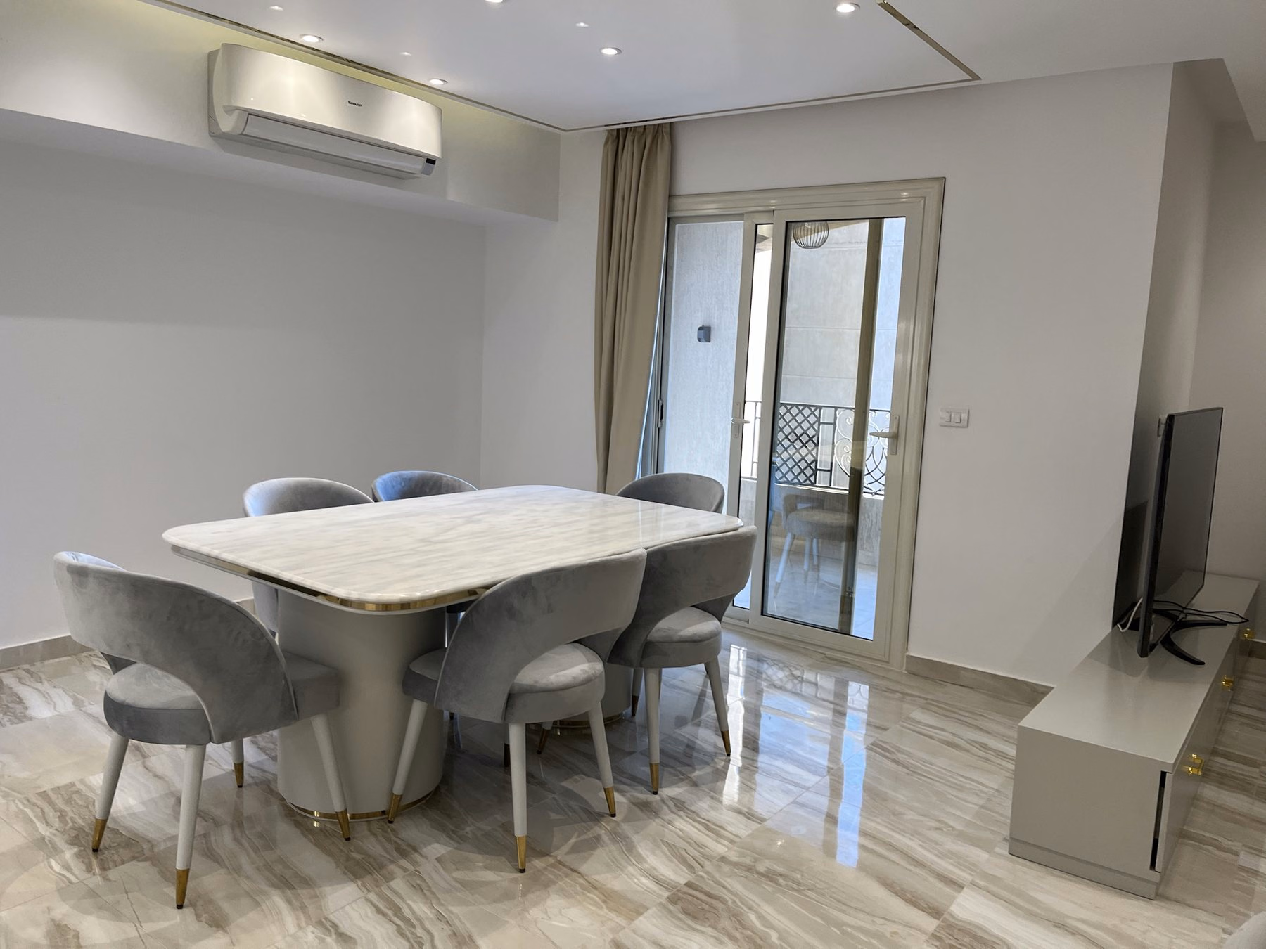 Dining area with marble table and balcony door